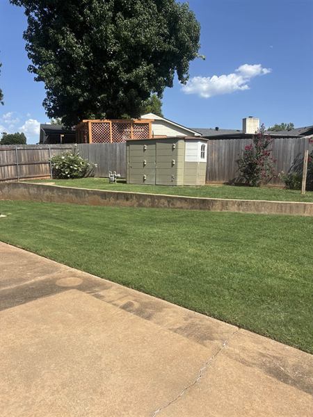 Backyard lawn mowed clean up to the fence line